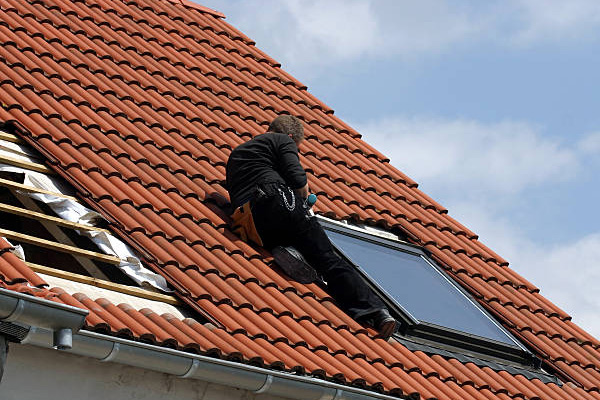 Couvreur professionnel intervenant sur une toiture à Gagny